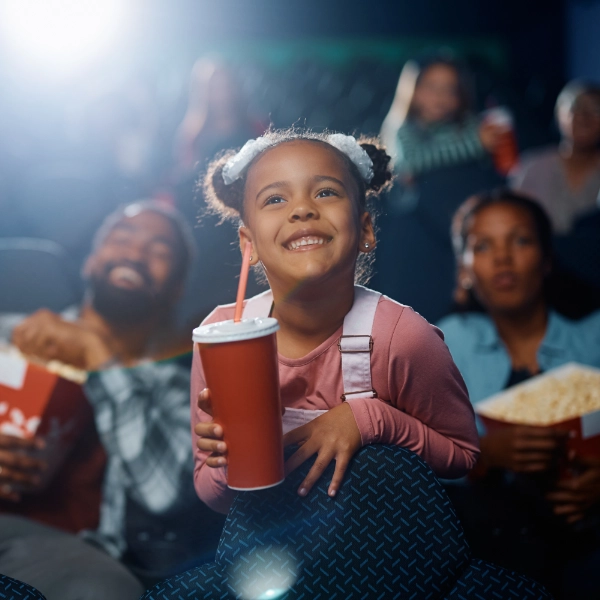 Little Girl At The Movies With Mom And Dad 600X600